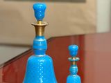 two blue vases sitting on a table next to each other