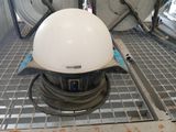 un casque blanc posé sur une grille métallique