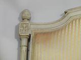 a white bed with a striped headboard and foot board