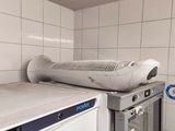 a white refrigerator in the corner of a room with a white tile wall