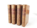 three old books sitting on top of each other on a white surface
