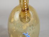 a yellow glass vase with a blue butterfly on it
