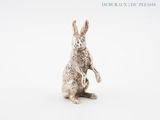 a close up of a silver rabbit figurine on a white background