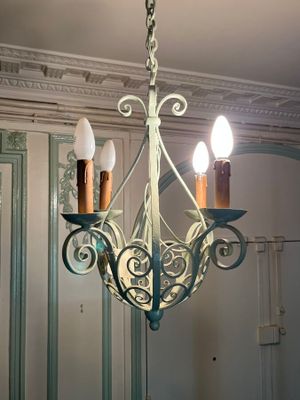 a picture of a chandelier with three candles hanging from it