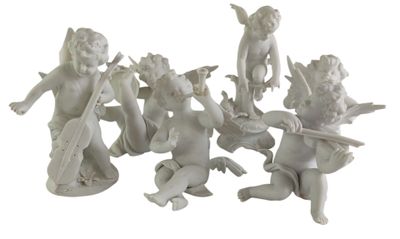 a group of figurines of angels sitting on a white surface