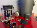 une table rouge sur laquelle sont posés des objets en argent et un seau en métal
