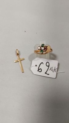 une petite croix et une bague en or sur un fond blanc