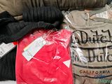a pile of clothing that is sitting on a bed