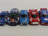 several toy cars are lined up in a row on a white surface
