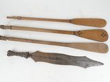 three old wooden spoons and a knife on a white surface