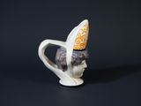 a white cup with a yellow hat on top of it