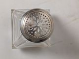 a silver metal strainer sitting on top of a white table