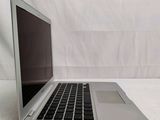 a silver laptop with a black keyboard on a white surface