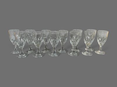 six verres à vin en cristal alignés sur une surface grise