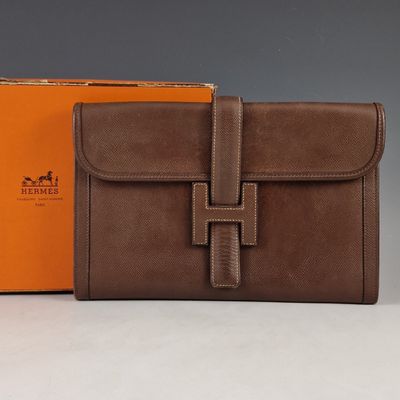 une photo d'un portefeuille en cuir marron muni d'une lanière marron