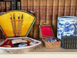 de nombreux livres sur une étagère, avec une machine à écrire et d'autres objets