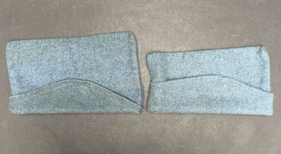 two pieces of blue felt are laying on a brown surface