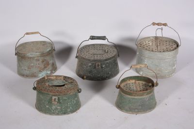 several old metal buckets are lined up on a white surface