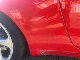 a close up of a red car ' s wheel and tire