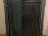 a black cabinet with a marble top on a wooden floor