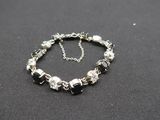 silver and black beaded bracelet on a black background