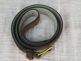leather belt with a brass buckle on a white background