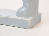 a white vase sitting on top of a white shelf