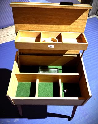 une petite boîte en bois compartimentée, posée sur un fond bleu