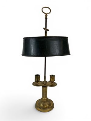 une lampe de table ancienne en laiton avec un abat-jour noir sur fond blanc