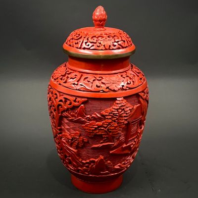 a red vase with a dragon on it on a black background