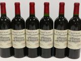 six bouteilles de vin rouge sont alignées sur une table
