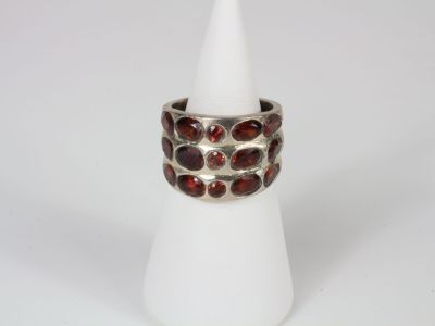 a close up of a silver ring with garnets on it