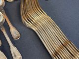 many spoons and forks laid out on a table