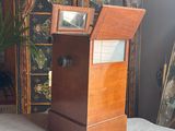 a small wooden box sitting on a bed next to a dresser