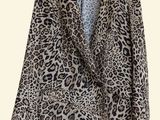 a leopard print jacket hanging on a hanger on a wall