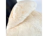 a white teddy bear that is sitting on a chair
