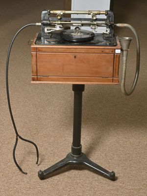 un tourne-disque posé sur un support, avec un ordinateur portable dessus