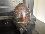 an egg sitting on a stand on a black table