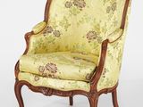 une chaise jaune dont le dossier et les accoudoirs sont recouverts d'un tissu à motifs floraux