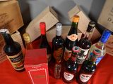 several bottles of wine are sitting on a red table cloth