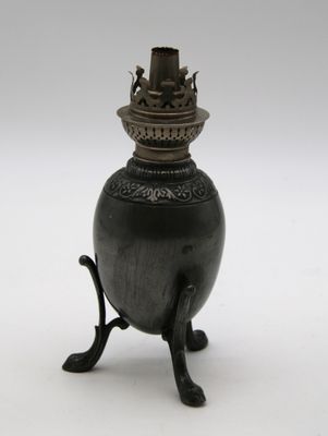 un vase noir posé sur un socle, sur une surface blanche