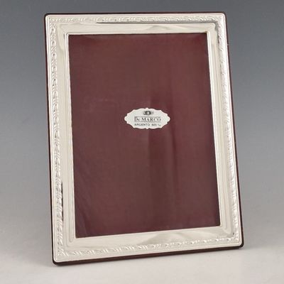 un cadre photo ancien en métal argenté, avec un fond rouge