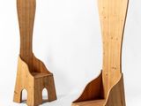 two wooden chairs sitting next to each other on a white surface