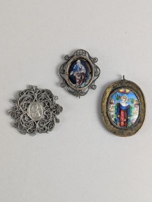 trois bijoux sont présentés sur une surface blanche