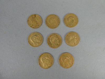 six gold coins are arranged in a triangle on a white surface