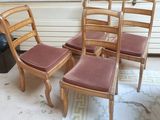quatre chaises en bois posées sur un tapis devant une fenêtre