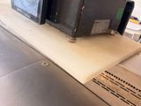 une personne debout devant un tapis roulant sur lequel se trouve une boîte