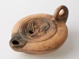 un vase marron orné d'un oiseau sur un fond blanc