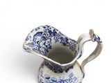 a blue and white pitcher on a white surface