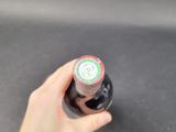 a person holding a bottle of beer in their hand